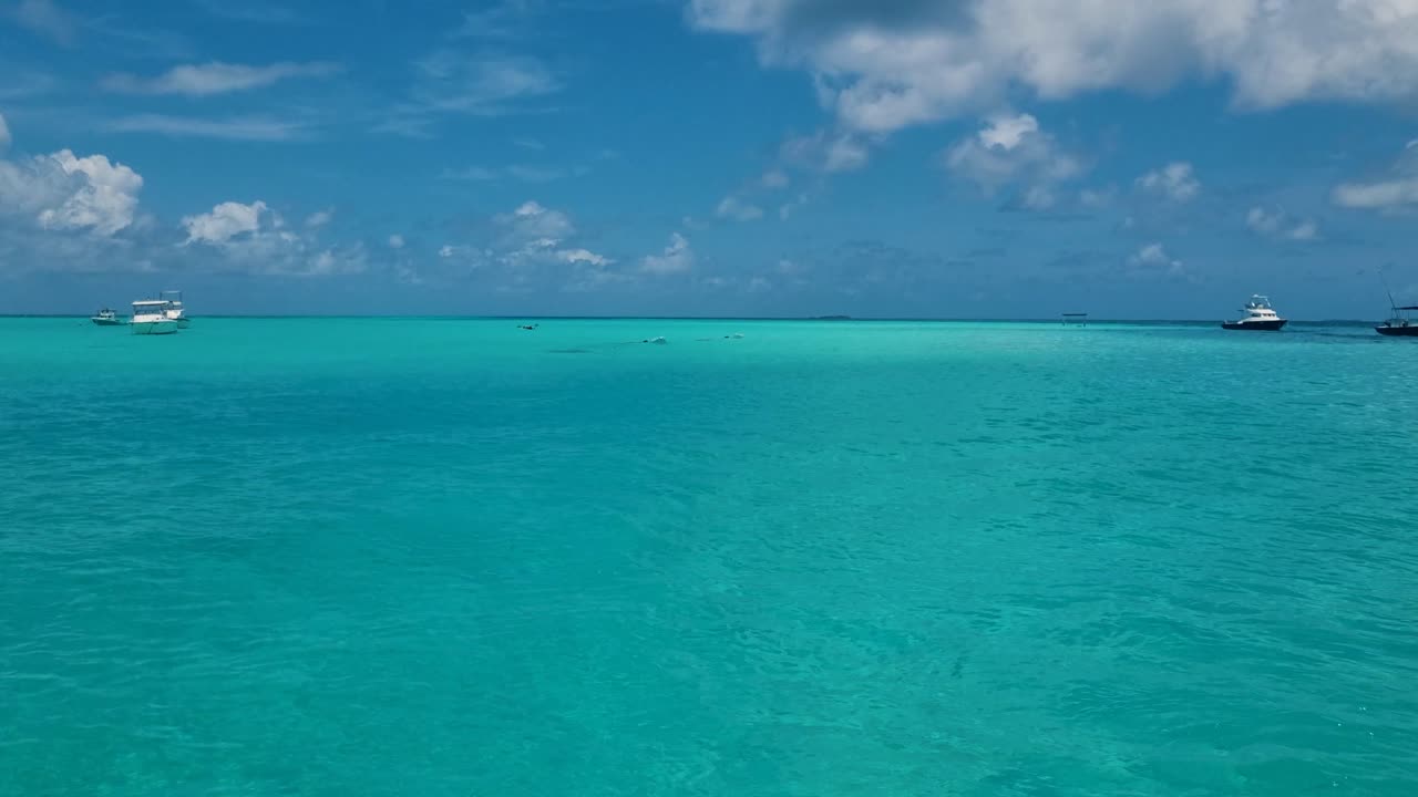Vista pittoresca della calma dell'Oceano Indiano alle Maldive, con acque turchesi e un cielo azzurro brillante, che evoca serenità e l'essenza di un paradiso tropicale.