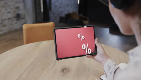 Biracial-woman-using-tablet-at-cafe-online-shopping-during-sales,-slow-motion