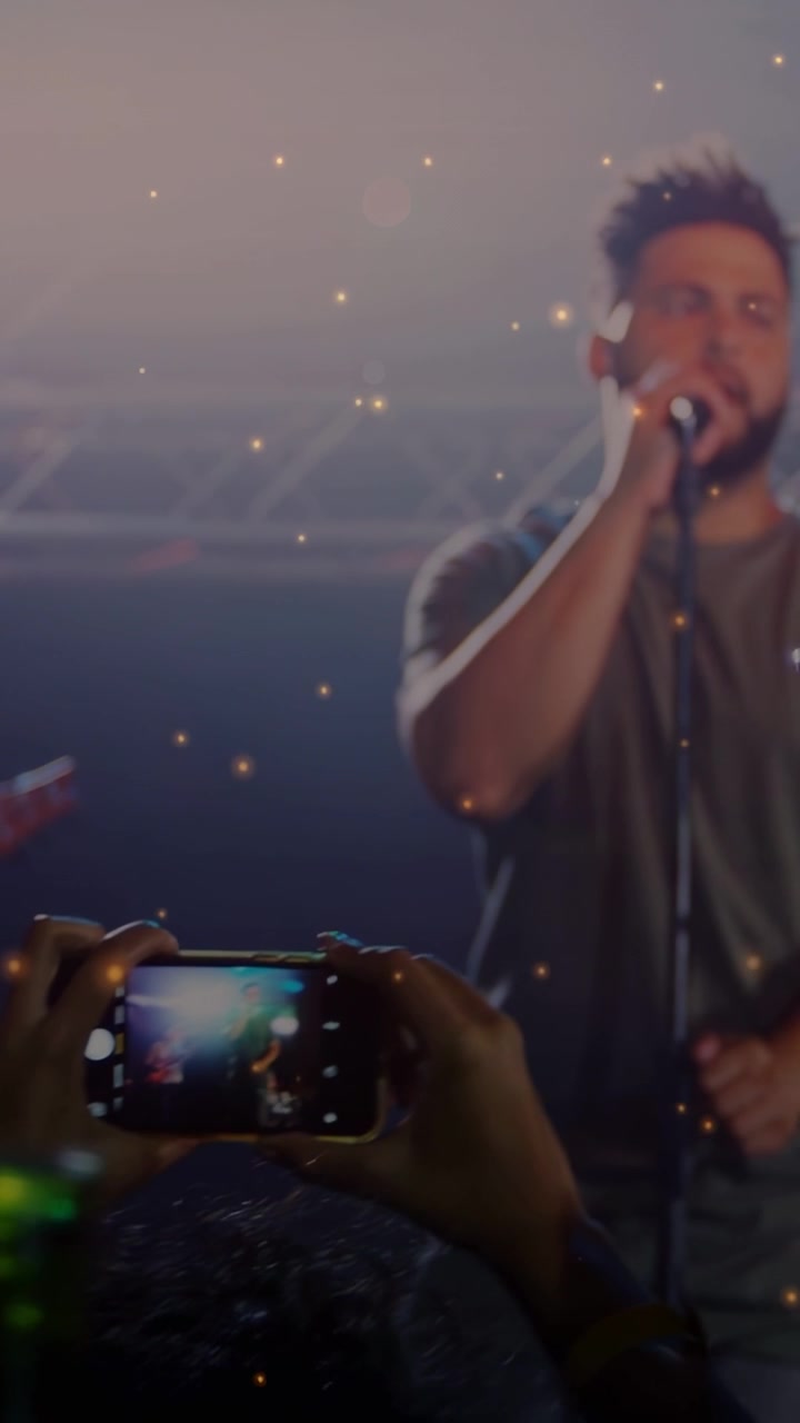 Video verticale: Il telefono che provoca una panoramica della telecamera, il cantante principale che si sposta al centro e canta nel microfono a un concerto.