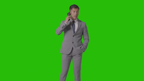 Three-Quarter-Length-Studio-Shot-Of-Unhappy-Businessman-In-Suit-Talking-On-Mobile-Phone-Against-Green-Screen-3