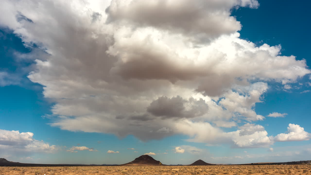 las nubes ruedan por el cielo sobre el duro paisaje del desierto de mojave hacia las montañas en este rápido lapso de tiempo
