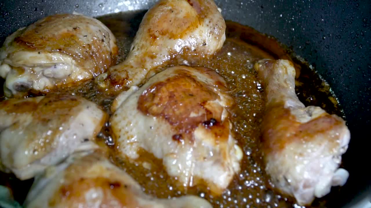 paneo a cámara lenta tiro pollo crujiente cocinado en burbujeante salsa marrón dorada, alimentos grasos