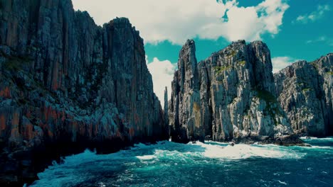 cape hauy drone flys at sea level towards cliffs in tasmania, australia