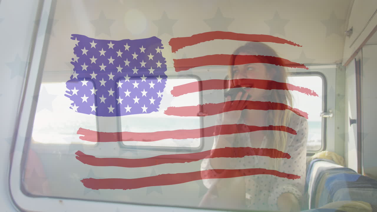 animación de la bandera estadounidense dibujada sobre una mujer caucásica en el coche usando un teléfono inteligente en la orilla del mar