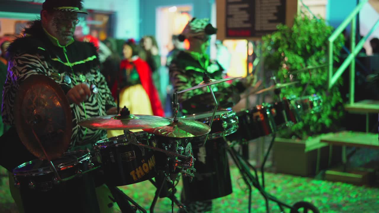Band in costumes playing music on stage outdoor during carnival party at night
