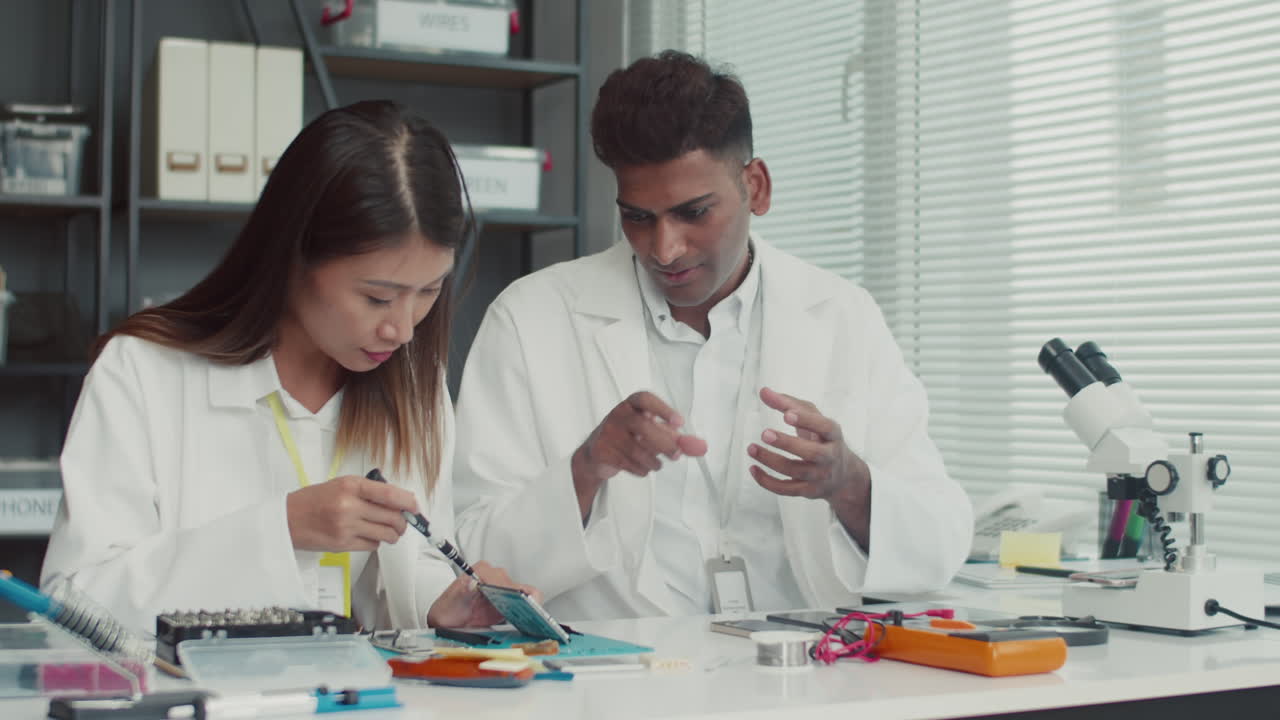 Repairpeople Discussing How to Fix Broken Device Component