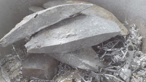 hand pouring molten lead into a mold, with focus on the shimmering liquid metal, close up