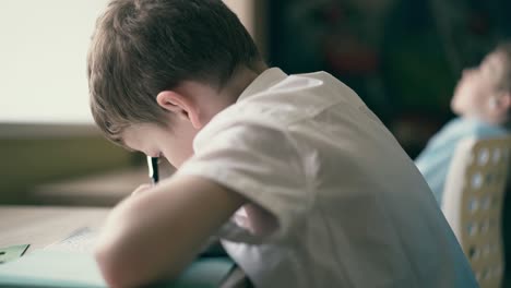 Children-do-their-homework-one-sits-at-the-table-with-notebooks