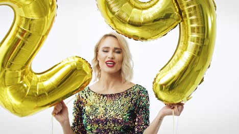 Frau-Mit-Goldenen-Luftballons-Baut-Die-Figur-„29“
