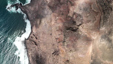 A-high-altitude-aerial-of-a-Canary-Island-coastline,-topview-of-the-300m-cliffs-at-Famara-beach