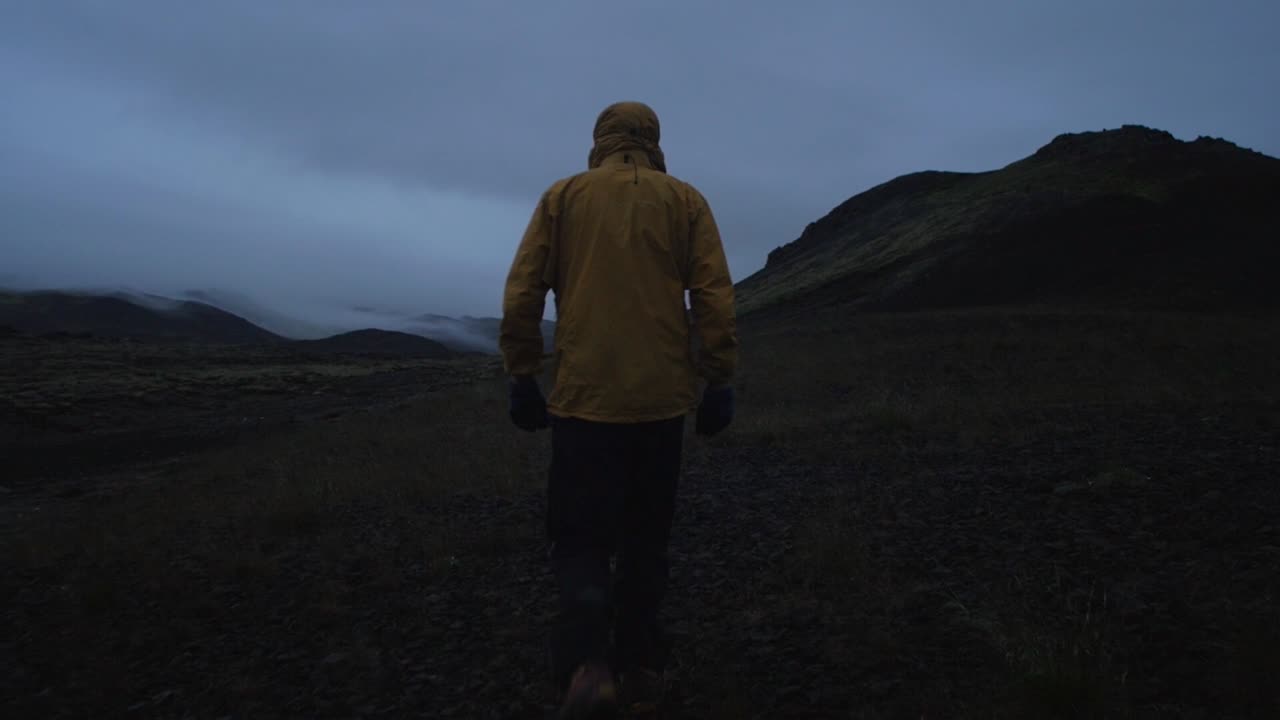 iceland, person walking through barren volcanic landscape at night, wide angle lens shot