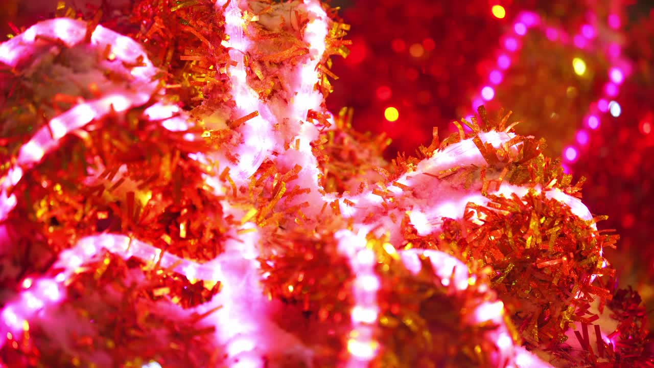 다채로운 반이는 크리스마스 장식. 거리의 클로즈업에서 네온 빛나는 박이는 장식. 새해 축하. 밤 마을에서 겨울 휴가 축하. 4k 영상