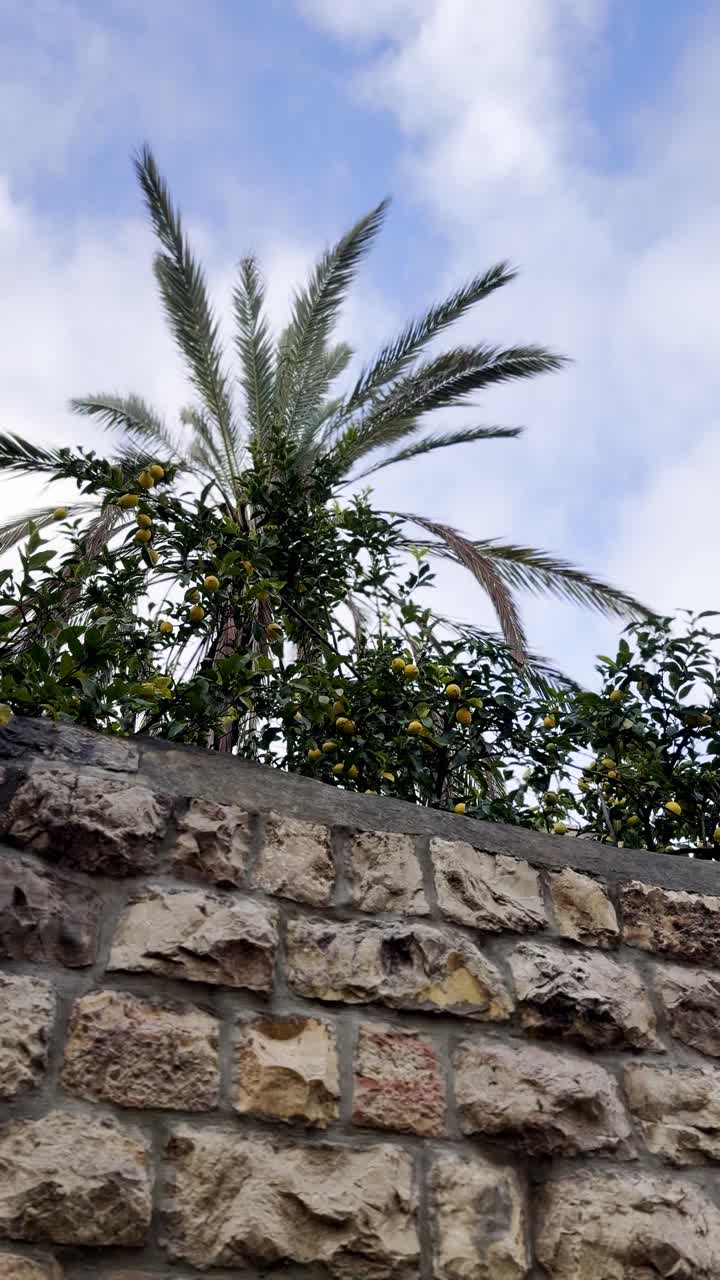 A wall made of stone blocks with a building in the background. Jerusalem old city wall.
