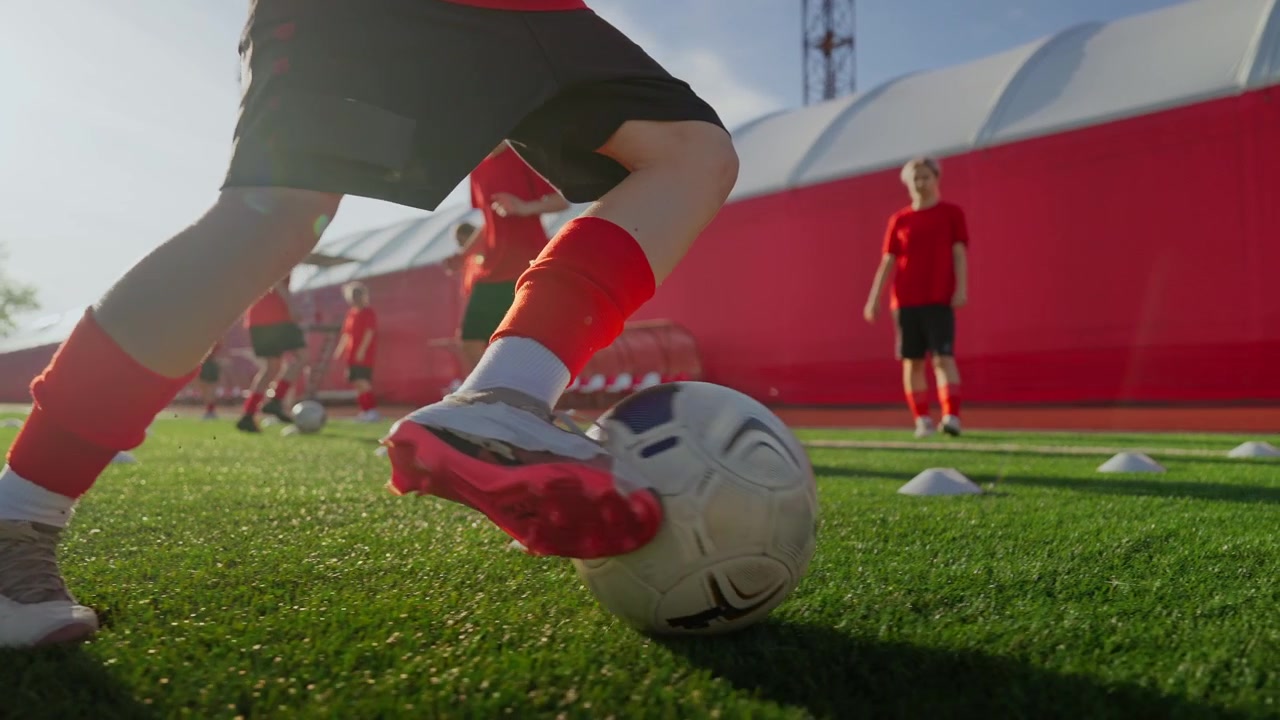 Jóvenes futbolistas practicando habilidades de regate en el campo