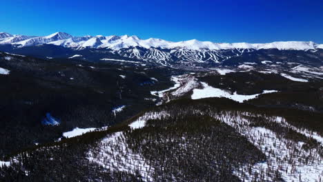 ten mile breck peaks breckenridge ski resort town vail epic ikon pass aerial drone landscape sunny winter morning blue sky ski trail runs summit county tiger fork road rocky mountains pan up forward