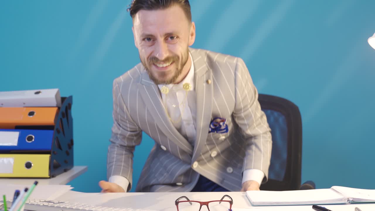 забавный и веселый бизнесмен, работающий за своим столом.