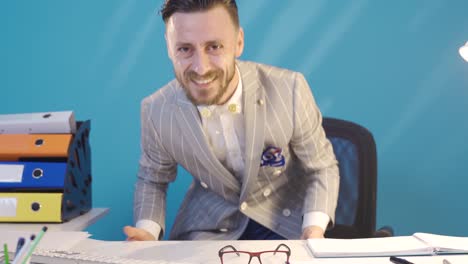 hombre de negocios divertido y alegre trabajando en su escritorio.