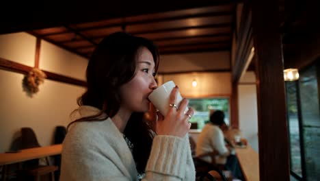 Woman enjoying a drink in a cozy Japanese cafe