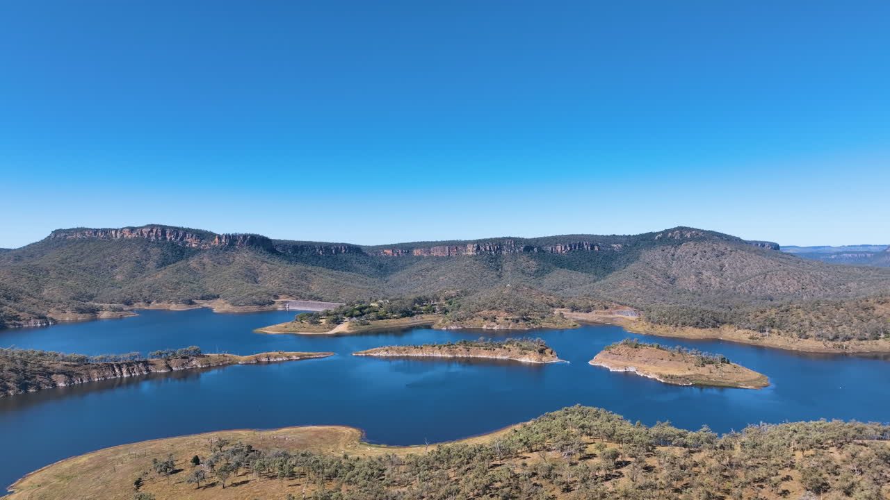 Aerial captures the complex geography of Cania Dam wall, Cania Lake, headlands into the waters and small isles off the National Park recreation area