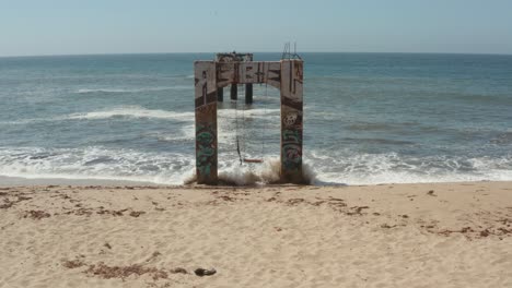 aerial view of old broken pier made of cement in the middle of the ocean near santa cruz california