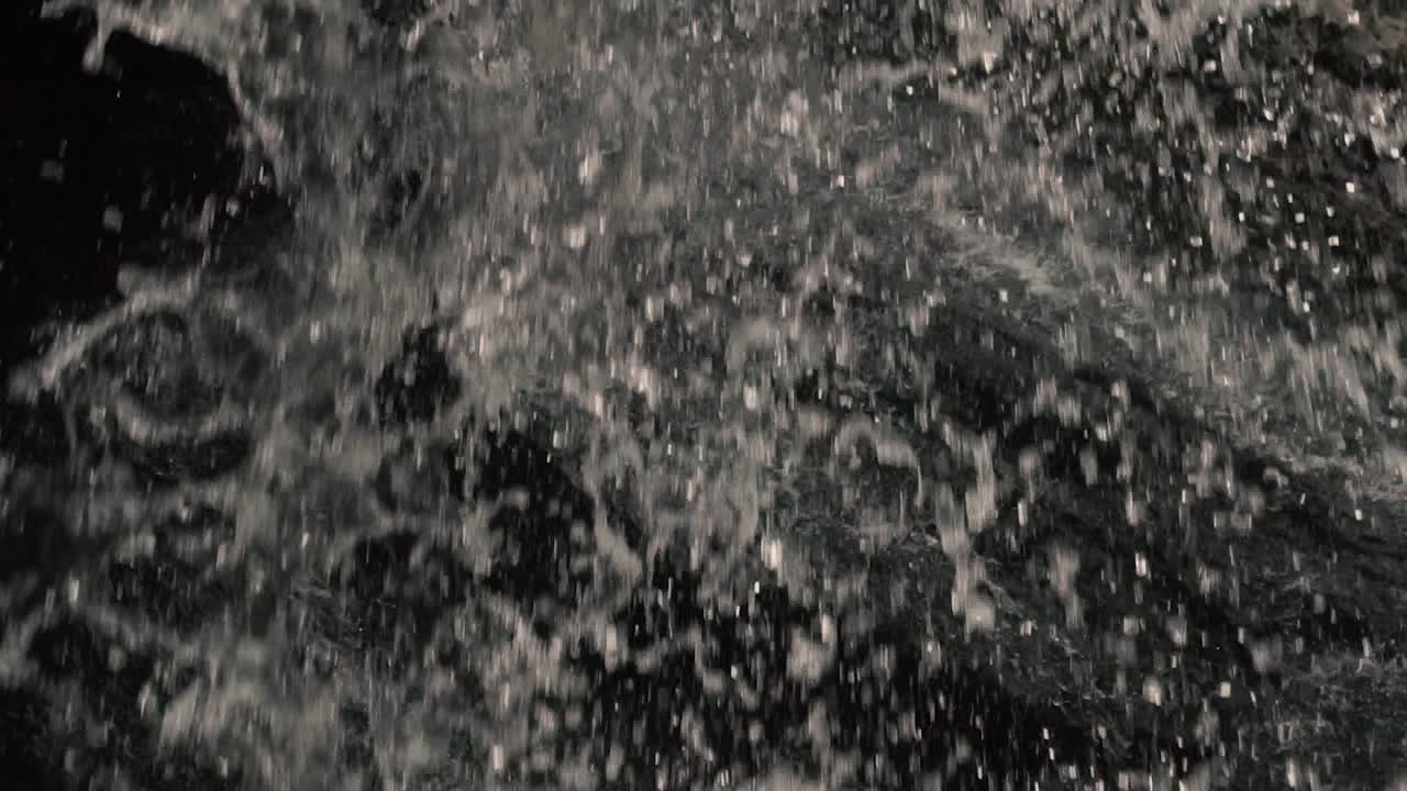 agua clara cayendo desde la construcción de un antiguo molino de madera hasta un río poco profundo en cámara lenta