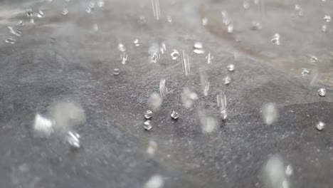 Slow-motion-bouncing-glass-beads-raining-down-on-ground