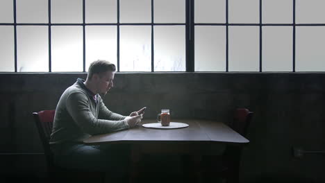 man sitting at a table using a cell phone
