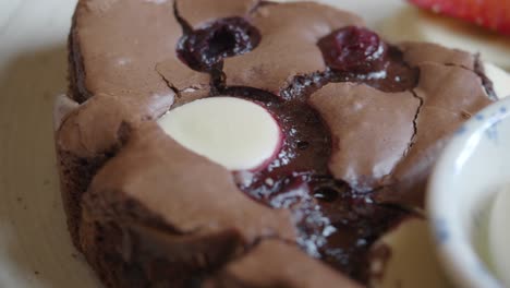 close-up of a piece of chocolate brownie with cherries and white chocolate