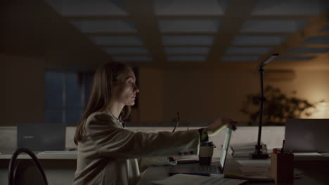 businesswoman working on laptop, feeling tired and leaving office at night