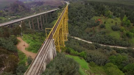 beeindruckende gelbe eisenbahnbrücke über autobahn und tal