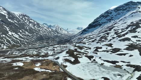 Sognefjellet-towards-Utladalen-valley-and-Smorstabb-glacier-during-summer-spring-day---Sognefjell-mountain-pass-road-seen-in-lower-frame-with-boverdalen-valley-behind-camera