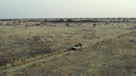 Vehicle-Driving-in-African-Grasslands-in-Namibia-Savannah,-Aerial-Establishing-Shot
