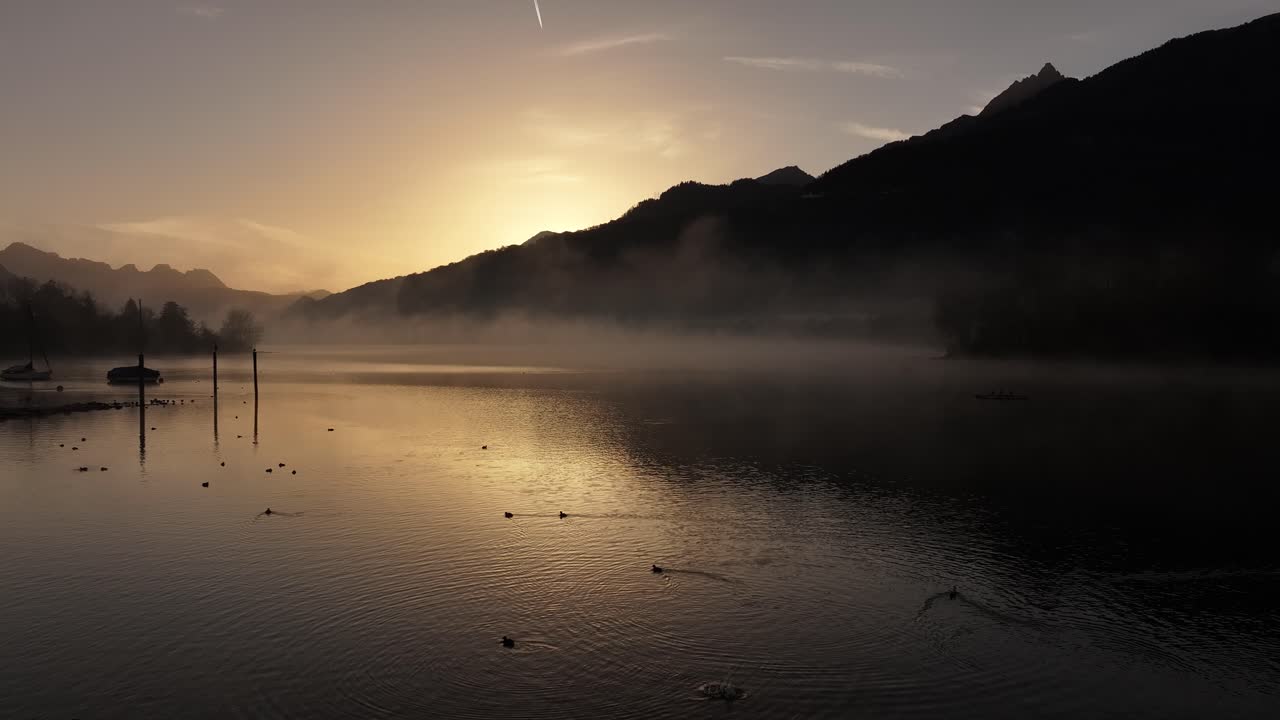 스위스 의 산 들 의 실루 과 함께 안개 가 가득 한 발렌세 호수 위 에서 해가 뜨는 것