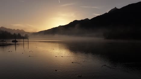 amanecer sobre un lago nebuloso walensee con siluetas de montañas en suiza