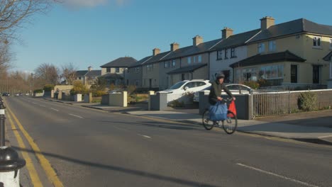 man cycling along quiet road with shopping bags