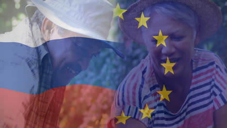 gardening together, elderly couple with russian and european union flags overlay
