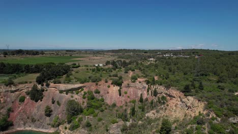 Aerial-view-of-countryside-landscape-near-Montpellier,-flying-above-lake,-sunny