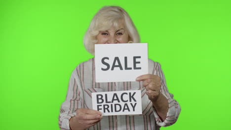 Grandmother-showing-Sale-word-and-Black-Friday-inscription-advertisement-banners,-rejoicing-discount