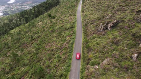 Toma-En-4k-De-Un-Dron-Rastreando-Un-Auto-Rojo-En-Su-Viaje-Por-Carretera-Por-El-Norte-De-Galicia