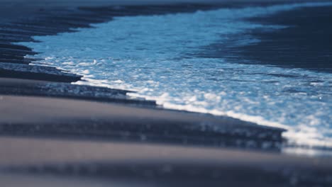 waves break around the sandy shallows on the ersfjord beach