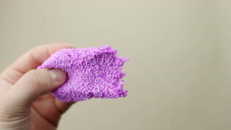destress therapy - purple slime torn apart by person hands, pov