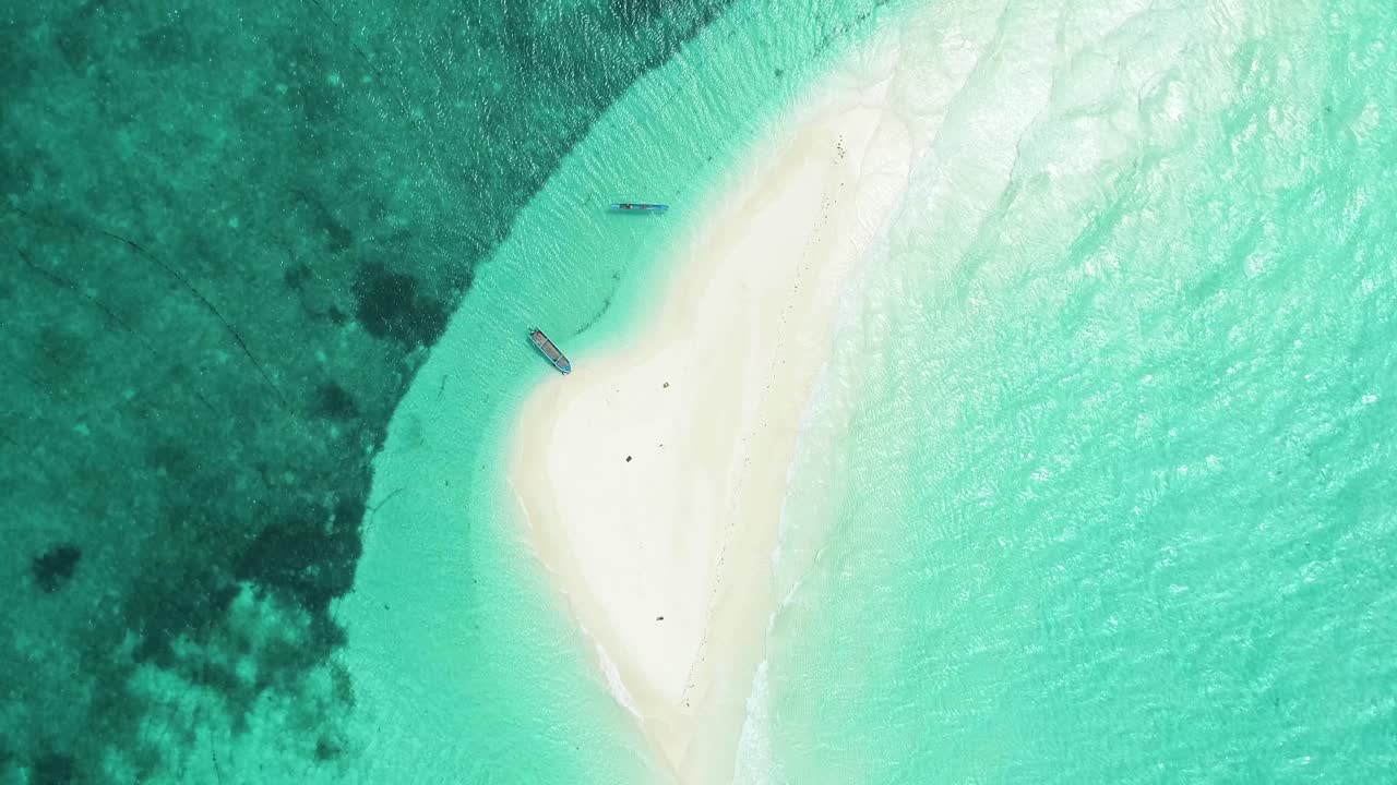 Una vista a volo d'uccello mostra barche e turisti che si godono l'Isola dei Serpenti, Indonesia.