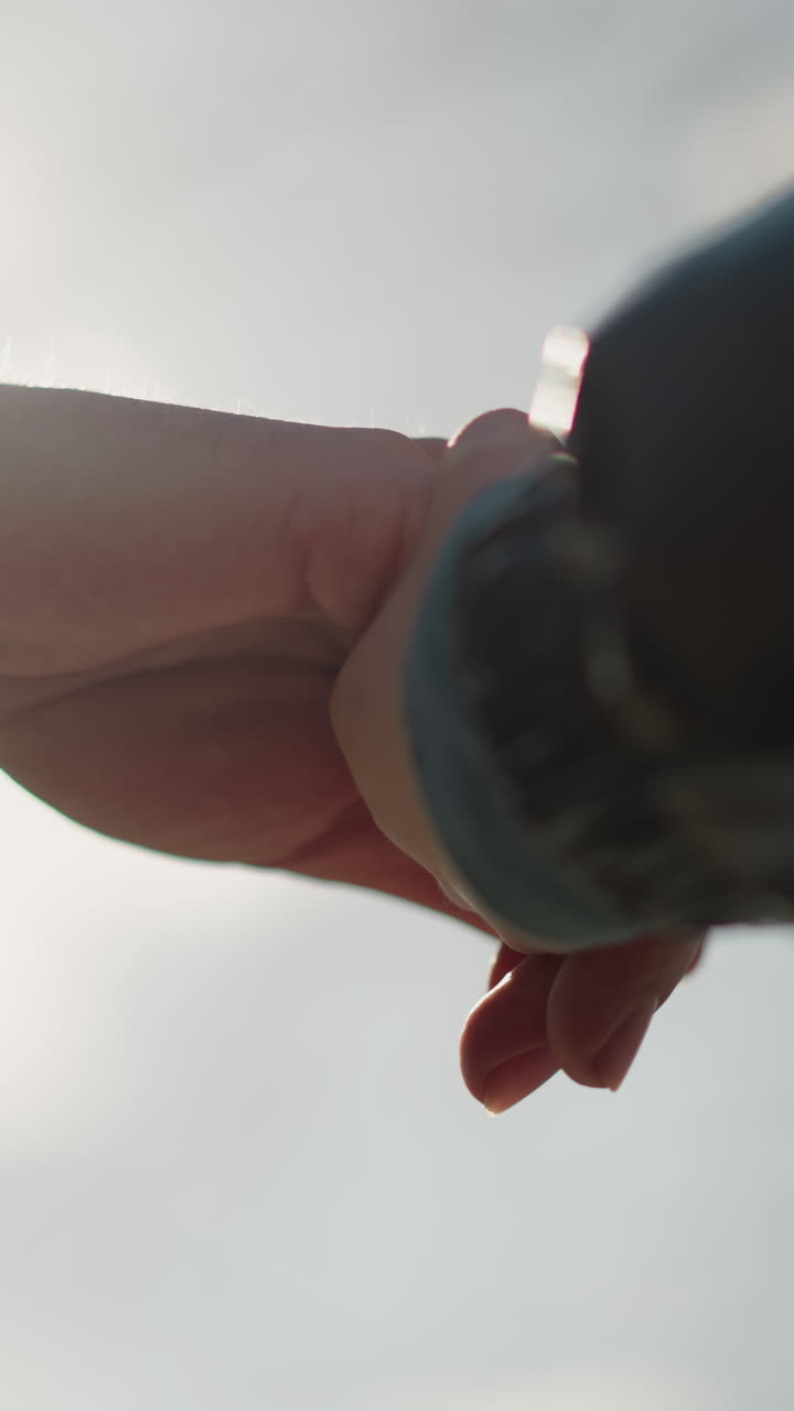 빛의 부드러운 빛에 의해 조명 된 두 사람이 손을 고 있는 클로즈업