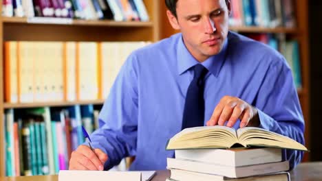 profesor de concentración preparando una clase en la biblioteca