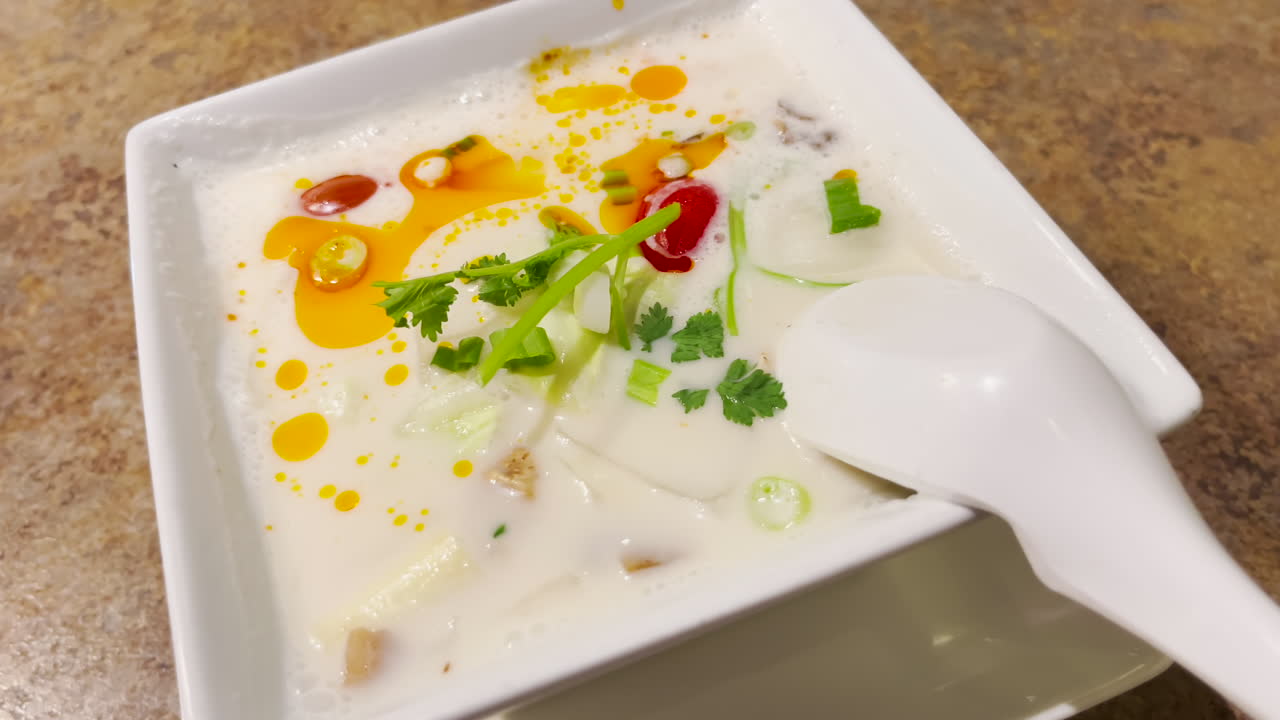 하얀 그릇에 담긴 톰 카 가이 타이 수프, 클로즈업 샷