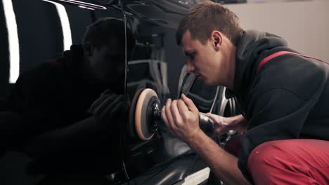 Proceso-De-Pulido-De-Coches-Nuevos-Negros-Con-Mashine-Profesional.-Hombre-Vestido-Con-Traje-Rojo-De-Una-Pieza-Trabajando-Duro.