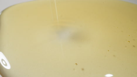gotas de aceite de jojoba caen en la superficie dejando rastros redondos