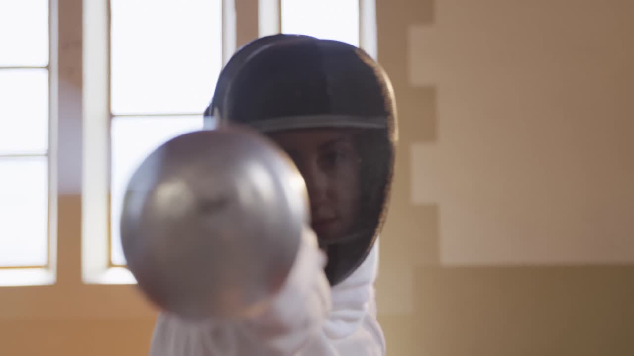 Atleta schermitrice durante un allenamento di scherma in palestra