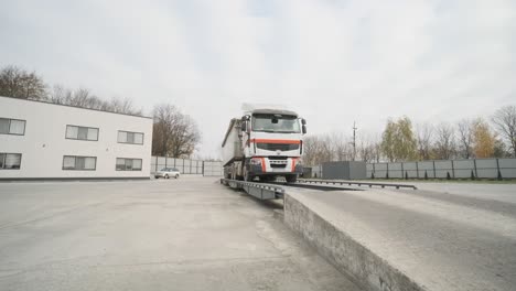 truck with raw materials is weighed on the scales in the grain storage area. truck scales