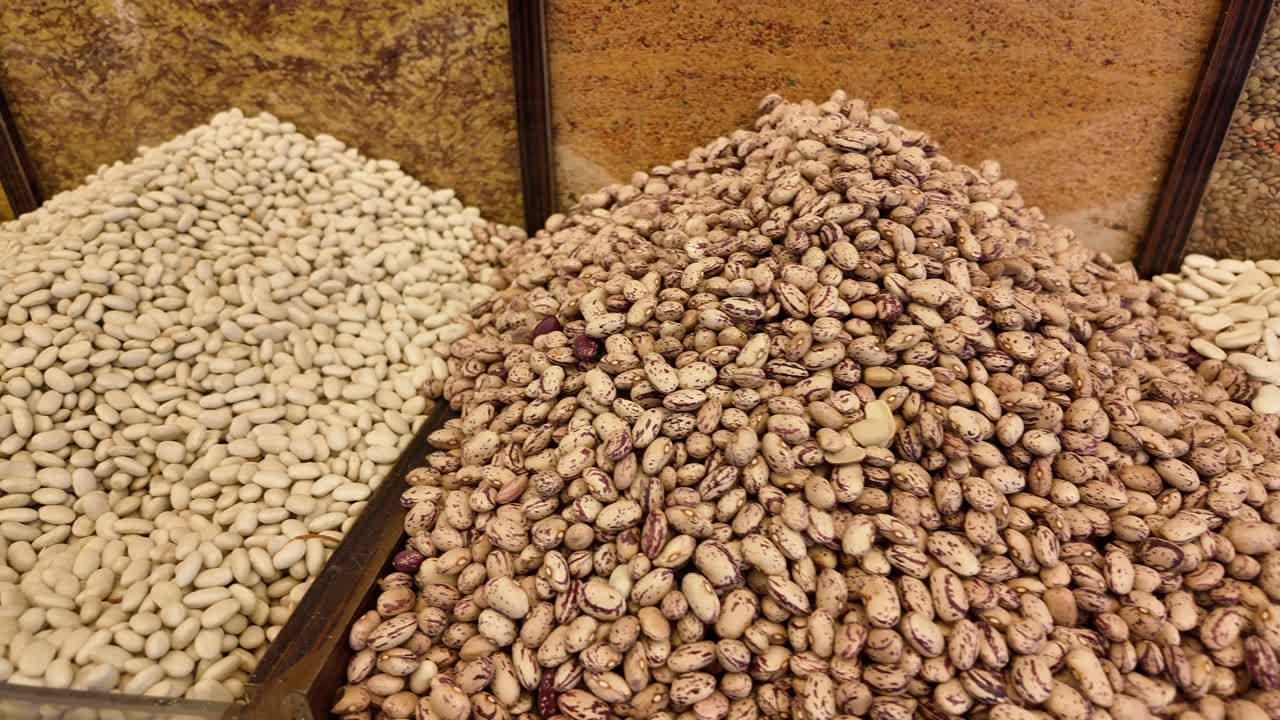 Piles of various beans for sale in a market